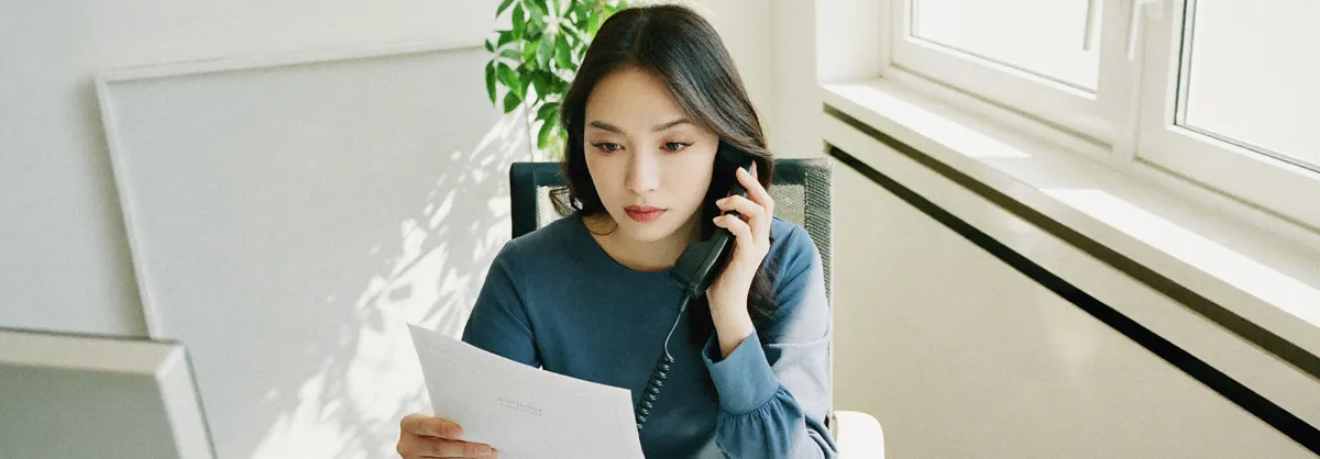 서류를 들고 전화로 묻는 모습