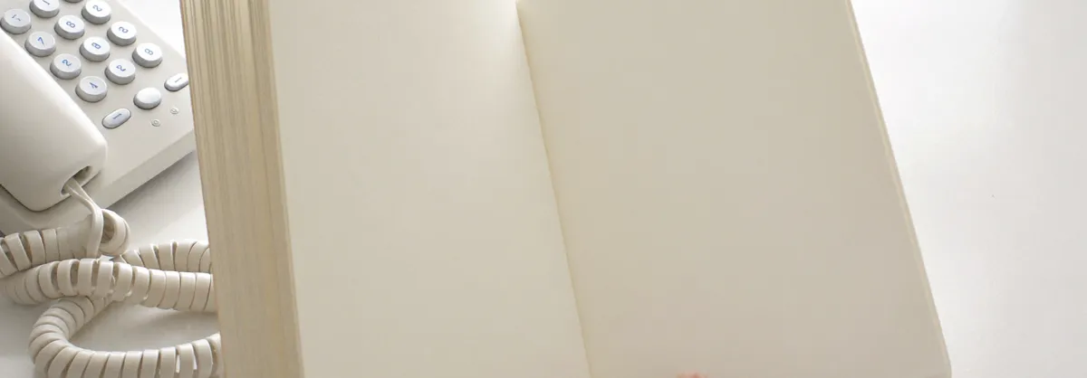 펼쳐 둔 수첩과 전화기
