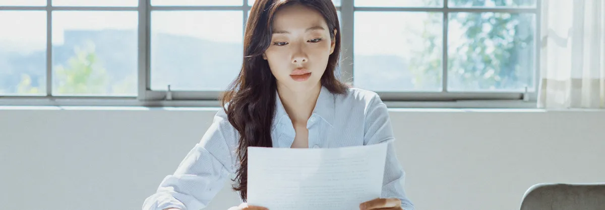 창가에서 계약서를 살펴보는 모습